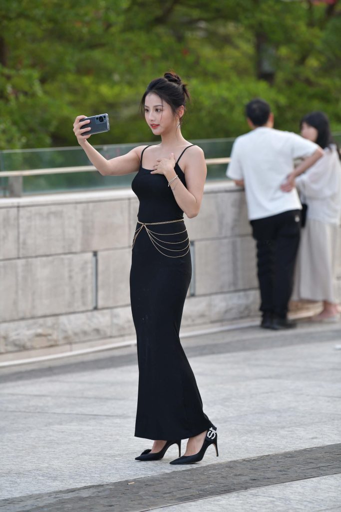 An elegant and beautiful young woman in a long black dress